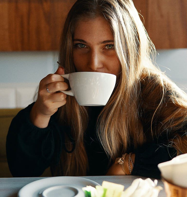 Cliente que bebe em uma xícara de café
